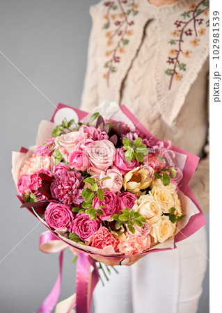 Beautiful bouquet of mixed flowers in woman hand. Floral shop concept . Beautiful fresh cut bouquet. Flowers delivery Beautiful bouquet of mixed flowers in woman hand. Floral shop concept . Beautiful fresh cut bouquet. Flowers delivery 102981539