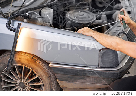 Removing dents on the car. PDR technology. Car body repair without painting. 102981702
