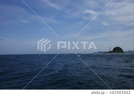 鳴門海峡を走るうずしお観潮船から見た白い灯台がある飛島 102983082