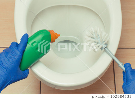 Hand of cleaner using domestic detergent and accessories for cleaning toilet. Household duties Hand of cleaner using domestic detergent and accessories for cleaning toilet. Household duties 102984533
