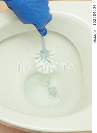 Hand of cleaner using brush for cleaning toilet. Household duties concept 102984534