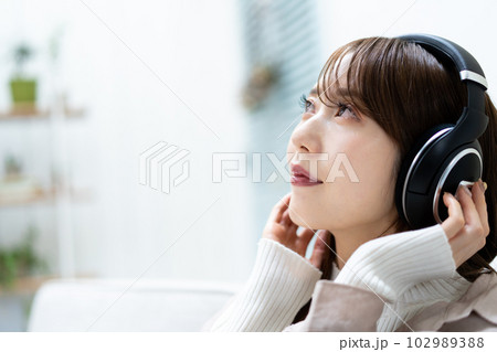 ソファーに座って音楽を聴く女性 102989388