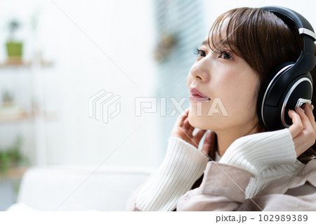 ソファーに座って音楽を聴く女性 102989389