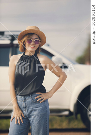 woman with straw hat toothy smiling with relaxing standing outdoor against suv car background 102991114