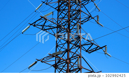 Large metal support of a high-voltage power line against a blue sky Large metal support of a high-voltage power line against a blue sky 102992425