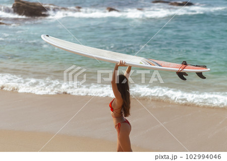 Surfer Woman with Surfboard in Tropical Paradise During Summer Sea Vacations Surfer Woman with Surfboard in Tropical Paradise During Summer Sea Vacations 102994046
