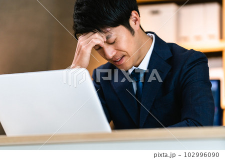 パソコンに向かって考えるビジネスマン 102996090
