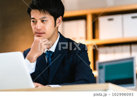 パソコンに向かって考えるビジネスマン パソコンに向かって考えるビジネスマン 102996093