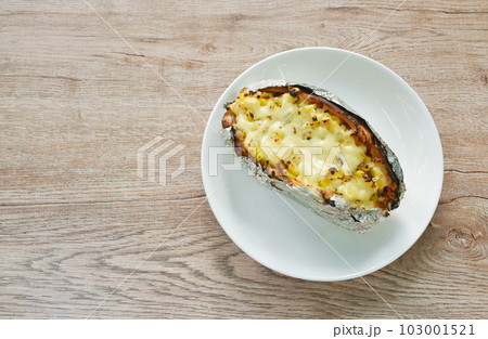 baking Japanese yam stuffing sweet corn seed with cheese in foil on plate baking Japanese yam stuffing sweet corn seed with cheese in foil on plate 103001521