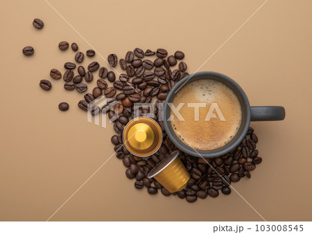 Coffee cup with fresh raw beans and coffee capsules on beige background. 103008545
