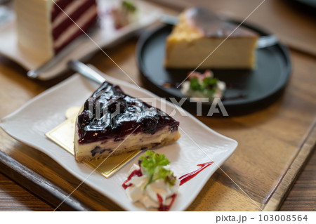 blueberry cheesecake with blur red velvet in coffee cafe blueberry cheesecake with blur red velvet in coffee cafe 103008564