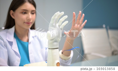 Technician testing robotic bionic arm at prosthetic manufacturing Technician testing robotic bionic arm at prosthetic manufacturing 103013858