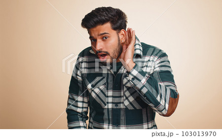 Indian man keeping arm near ear for louder voice, asking to repeat, to hear information, deafness 103013970