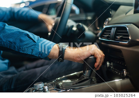 Close-up of a man's hand while shifting the automatic transmission of a car. 103025264