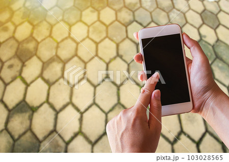 Businesswoman holding smartphone with blurred background 103028565