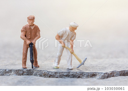 Figures construction worker, is working on a cracked area Figures construction worker, is working on a cracked area 103030061