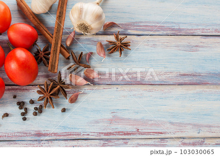 Close up garlic,red tomato,spices and herbs on a wooden table background 103030065