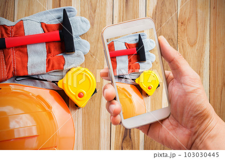 Hand holding smart phone with shoot safety equipment 103030445
