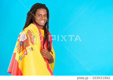 Latin man with dreadlocks wrapping with a spanish national flag Latin man with dreadlocks wrapping with a spanish national flag 103031982