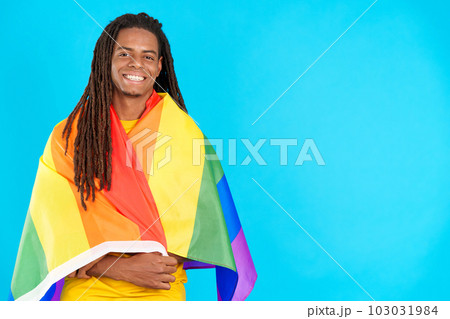 Happy latin man with dreadlocks wrapped with a lgbt flag 103031984