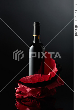 Bottle of red wine on a crumpled paper. 103031985