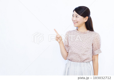 白い背景の前で人差し指を立てる30代の女性 白い背景の前で人差し指を立てる30代の女性 103032712
