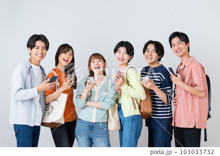 スマホを見る若い男女 103033732