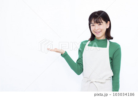 白い背景の前で紹介をしている30代の主婦 白い背景の前で紹介をしている30代の主婦 103034186