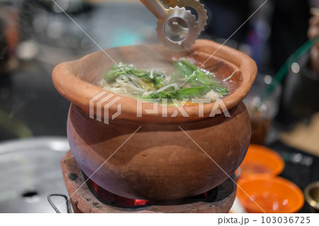 Jim Joom, Thai style of hot pot from the Northeast of Thailand contains pork, vegetable and glass noodle in clay bowl 103036725