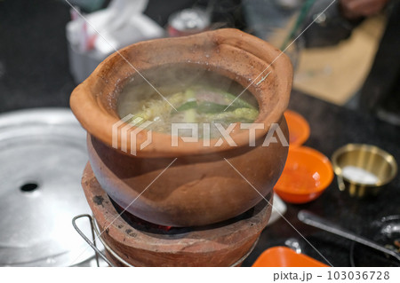 Jim Joom, Thai style of hot pot from the Northeast of Thailand contains pork, vegetable and glass noodle in clay bowl Jim Joom, Thai style of hot pot from the Northeast of Thailand contains pork, vegetable and glass noodle in clay bowl 103036728