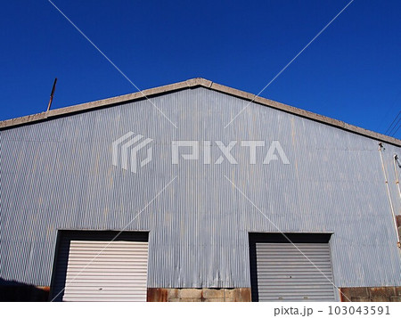 青空とトタン壁の倉庫の風景 103043591