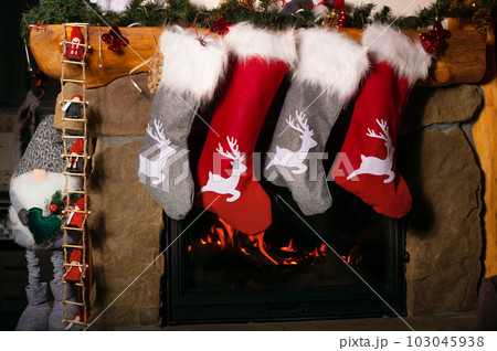 Christmas socks hanging on burning fireplace Christmas socks hanging on burning fireplace 103045938