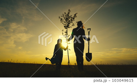 fresh tree seedling sunset, young roots, soil ground, plant garden, silhouette happiness family mother child, mother waters plant, teamwork, happy family silhouette, happy family team, ecology concept fresh tree seedling sunset, young roots, soil ground, plant garden, silhouette happiness family mother child, mother waters plant, teamwork, happy family silhouette, happy family team, ecology concept 103049615