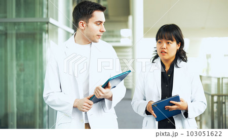 白衣を着てロビーを歩く多国籍グループ 103051622