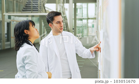 研究施設で会話する白衣を着た多国籍グループ 研究施設で会話する白衣を着た多国籍グループ 103051670