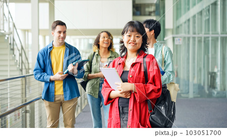 多国籍学生グループの前に立つ笑顔の女性 多国籍学生グループの前に立つ笑顔の女性 103051700