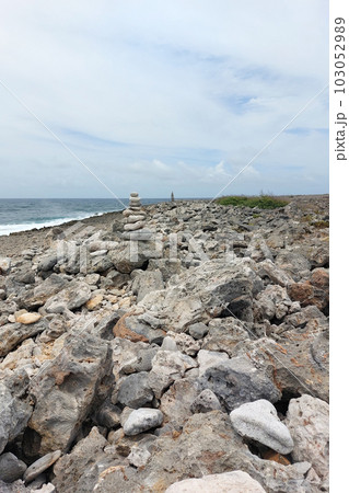 A high tower of flat stones stands on the seashore in cloudy weather 103052989