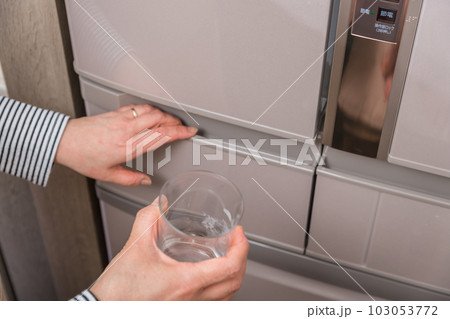 【製氷室から氷をグラスに入れる主婦】 【製氷室から氷をグラスに入れる主婦】 103053772