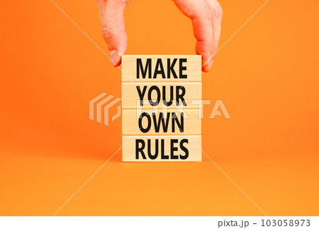 Make your own rules symbol. Concept words Make your own rules on wooden cubes. Beautiful orange table orange background. Businessman hand. Business motivational make your own rules concept. Copy space Make your own rules symbol. Concept words Make your own rules on wooden cubes. Beautiful orange table orange background. Businessman hand. Business motivational make your own rules concept. Copy space 103058973