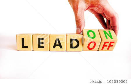 Lead on or off symbol. Businessman turns wooden cubes and changes word Lead off to Lead on. Beautiful white table white background. Business and lead on or off concept. Copy space. 103059002