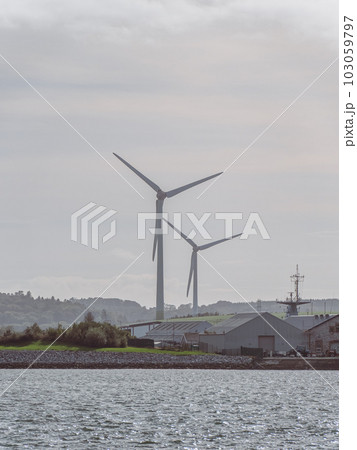 Wind power generators in the Ireland, landscape. Two wind turbines located in Ringaskiddy, County Cork. Cloudy overcast sky. wind turbine under cloudy sky 103059797