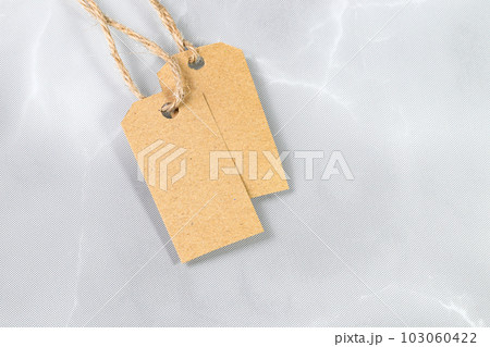 Blank tag tied with natural material string. Price tag, gift tag, sale tag, address label. Blank tag tied with natural material string. Price tag, gift tag, sale tag, address label. 103060422