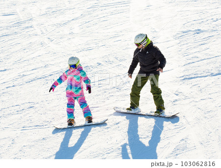 Ski instructors teaching young skier 103062816