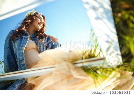 Portrait of a beautiful bride through mirror. Wedding concept. Stylish wedding. Great sunset light. Portrait of a beautiful bride through mirror. Wedding concept. Stylish wedding. Great sunset light. 103063031