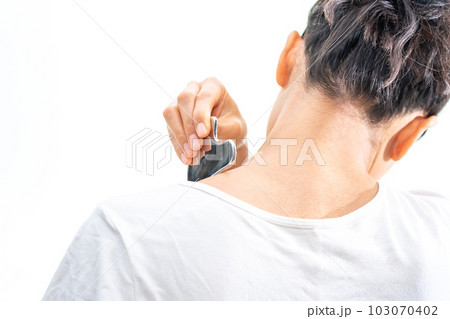 金属のマッサージプレートで肩をマッサージする若い女性 金属のマッサージプレートで肩をマッサージする若い女性 103070402