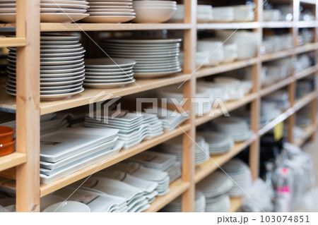 Plates displayed on shelving in household goods store 103074851