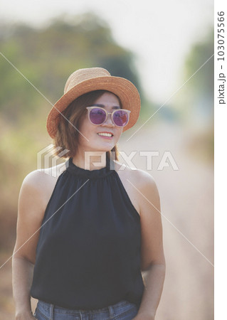 beautiful asian woman wearing straw hat toothy smiling with happiness standing outdoor against beautiful morning light beautiful asian woman wearing straw hat toothy smiling with happiness standing outdoor against beautiful morning light 103075566
