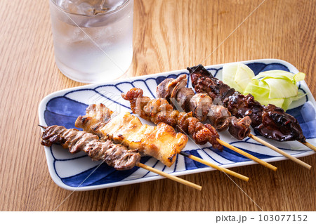 居酒屋の焼鳥盛り合せと焼酎 103077152