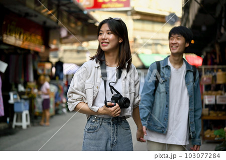 A female enjoys taking photos and sightseeing the old town market with her boyfriend 103077284