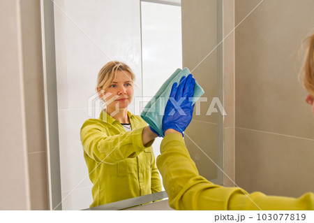 cleaning company. hotel maid microfiber cloth washing cleaning a mirror. household service concept 103077819